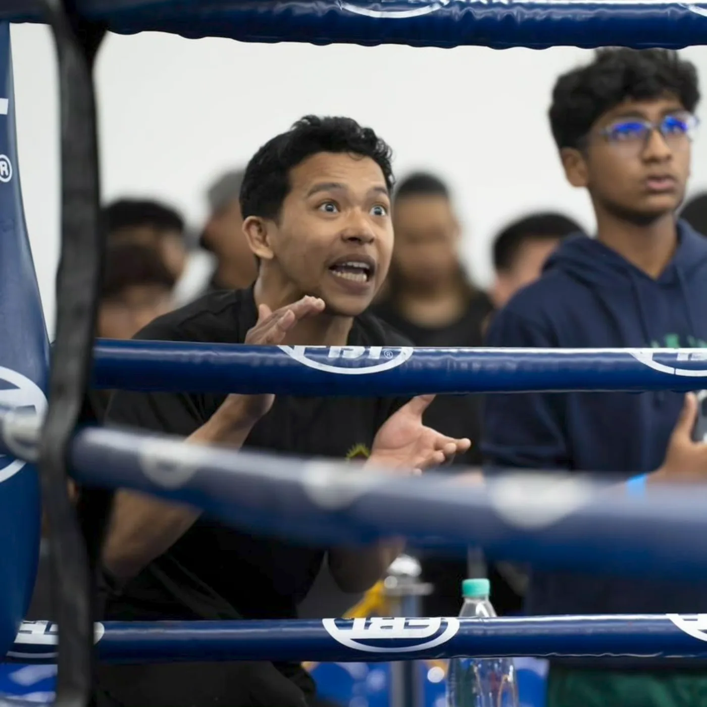 Coach Aiman ringside, animatedly encouraging his student mid-bout