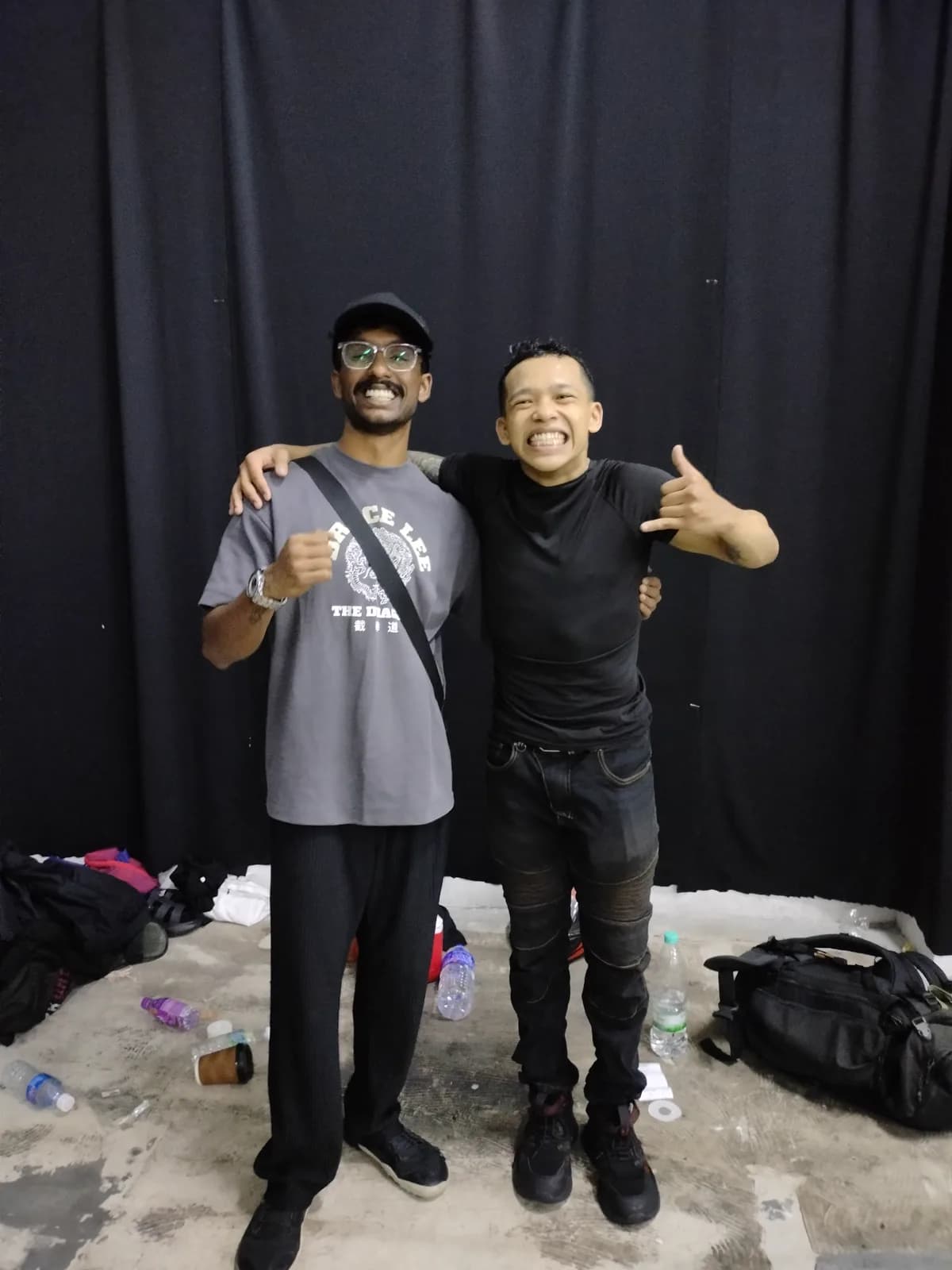 Coach Aiman and a friend grinning backstage after an event