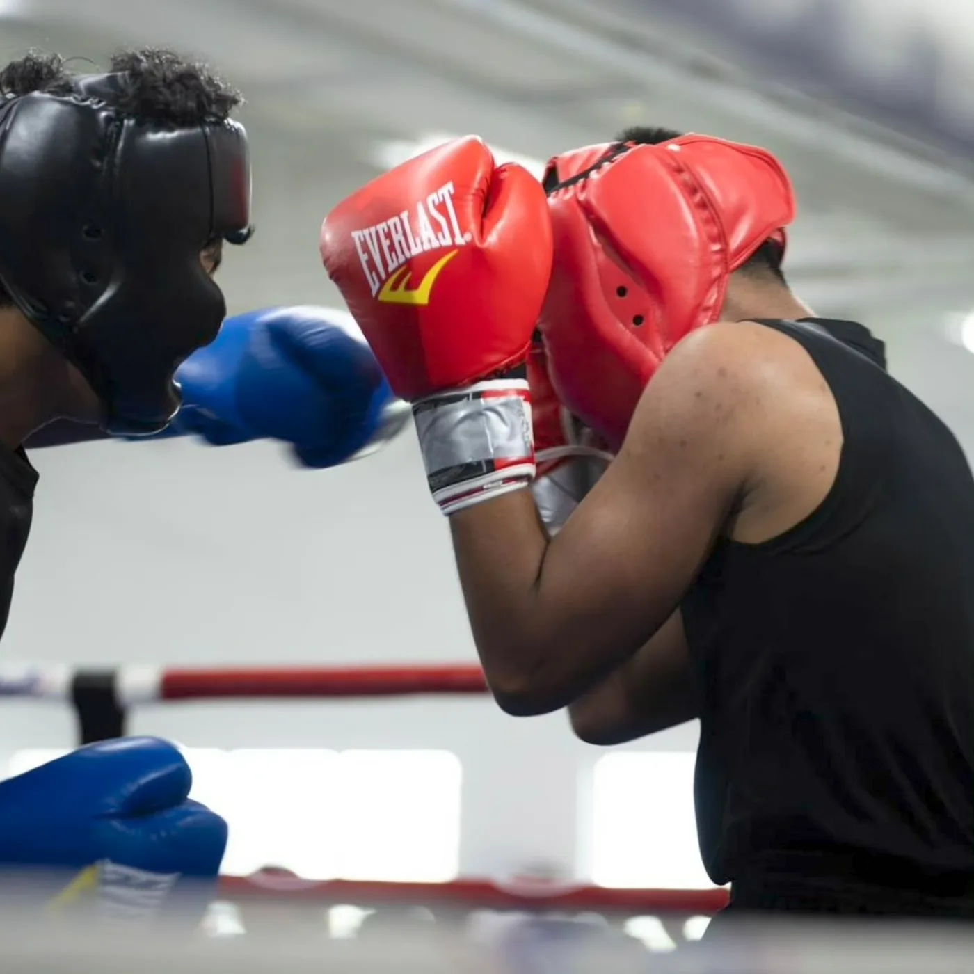 Two teens sparring in full protective headgear and gloves